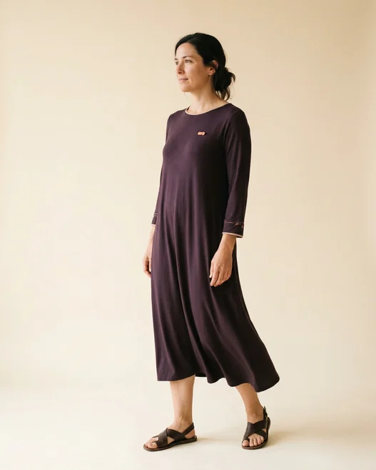 Cliente de corpo inteiro no provador, vestindo um vestido midi